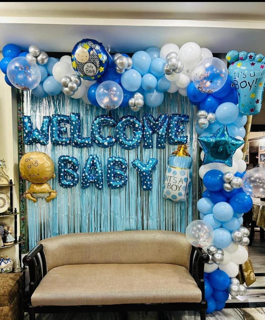 Welcome Baby decoration with blue, white and silver balloon garland, Welcome Baby foil letters, Baby Boy themed balloons, star and baby bottle foil balloons, transparent confetti balloons and silver balloon clusters. The decoration can also be customized for a baby girl with your choice of colours and theme, perfect for newborn baby welcome celebrations in Delhi NCR.