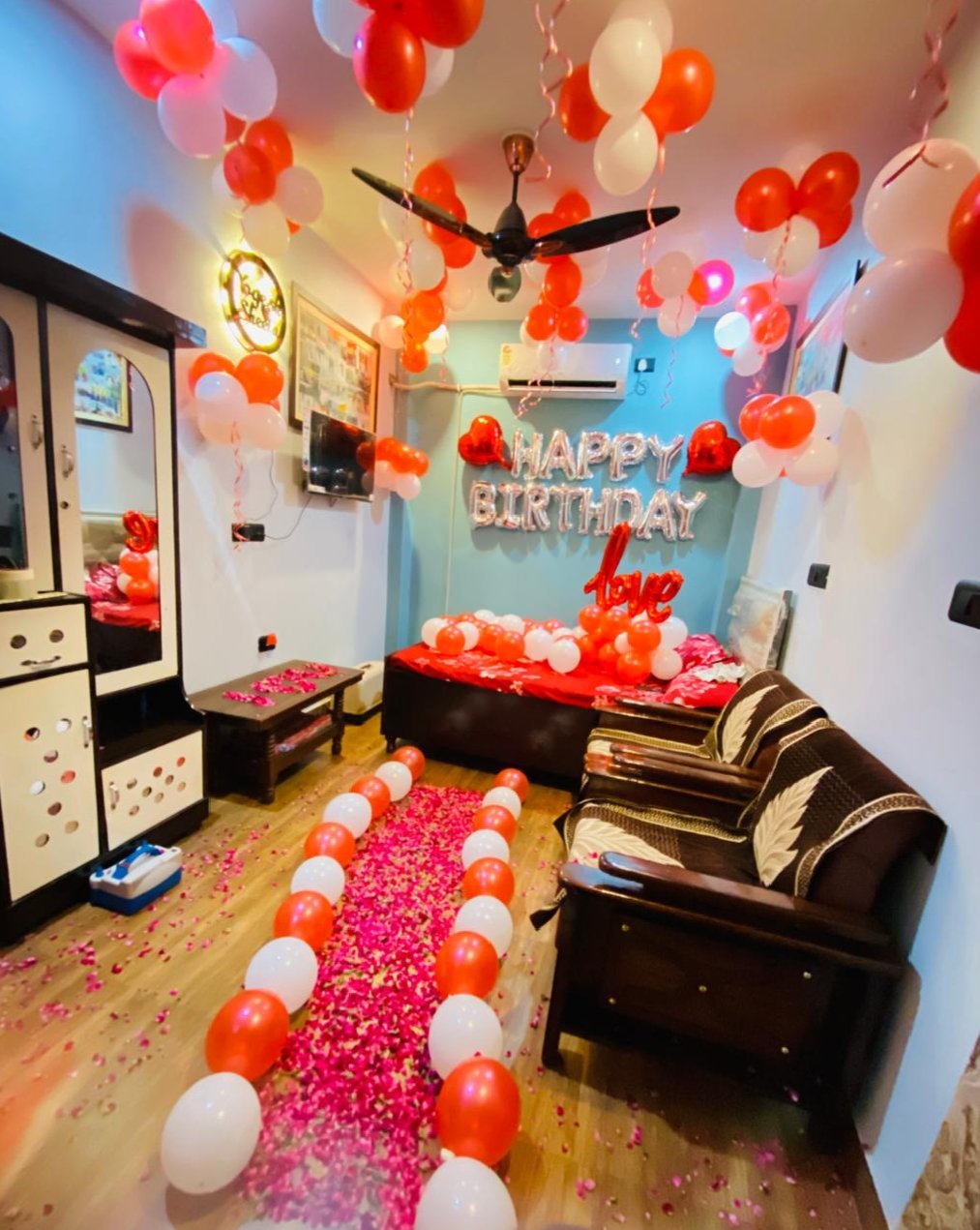 Surprise birthday room decoration with red and white balloons, ceiling balloon decoration, Happy Birthday foil letters, heart-shaped balloons, floor balloon arrangement and a beautiful rose petal pathway. This red and white birthday decoration is perfect for surprise birthday parties, romantic celebrations and home room decoration. Get customized balloon decoration according to your choice of colours, theme, name and age number. Balloon decoration near me and birthday party decoration services available across Delhi NCR, including Uttam Nagar, Janakpuri, Dwarka, Vikaspuri, Paschim Vihar, Nangloi, Palam, Rajouri Garden and Punjabi Bagh.
